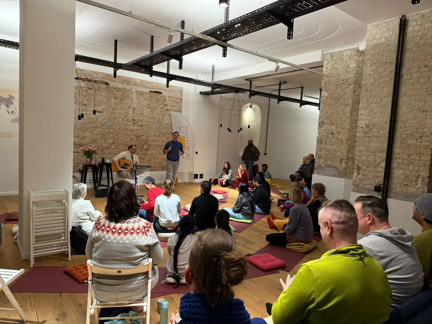 Teilnehmende sitzen entspannt im Kreis in der Yoga Oase Berlin